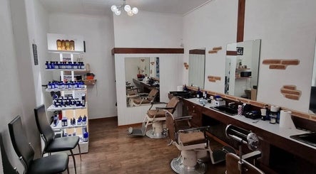 Intérieur moderne de Coiffure Men's à Genève, Genève, CH avec fauteuils de barbier et produits de soin.