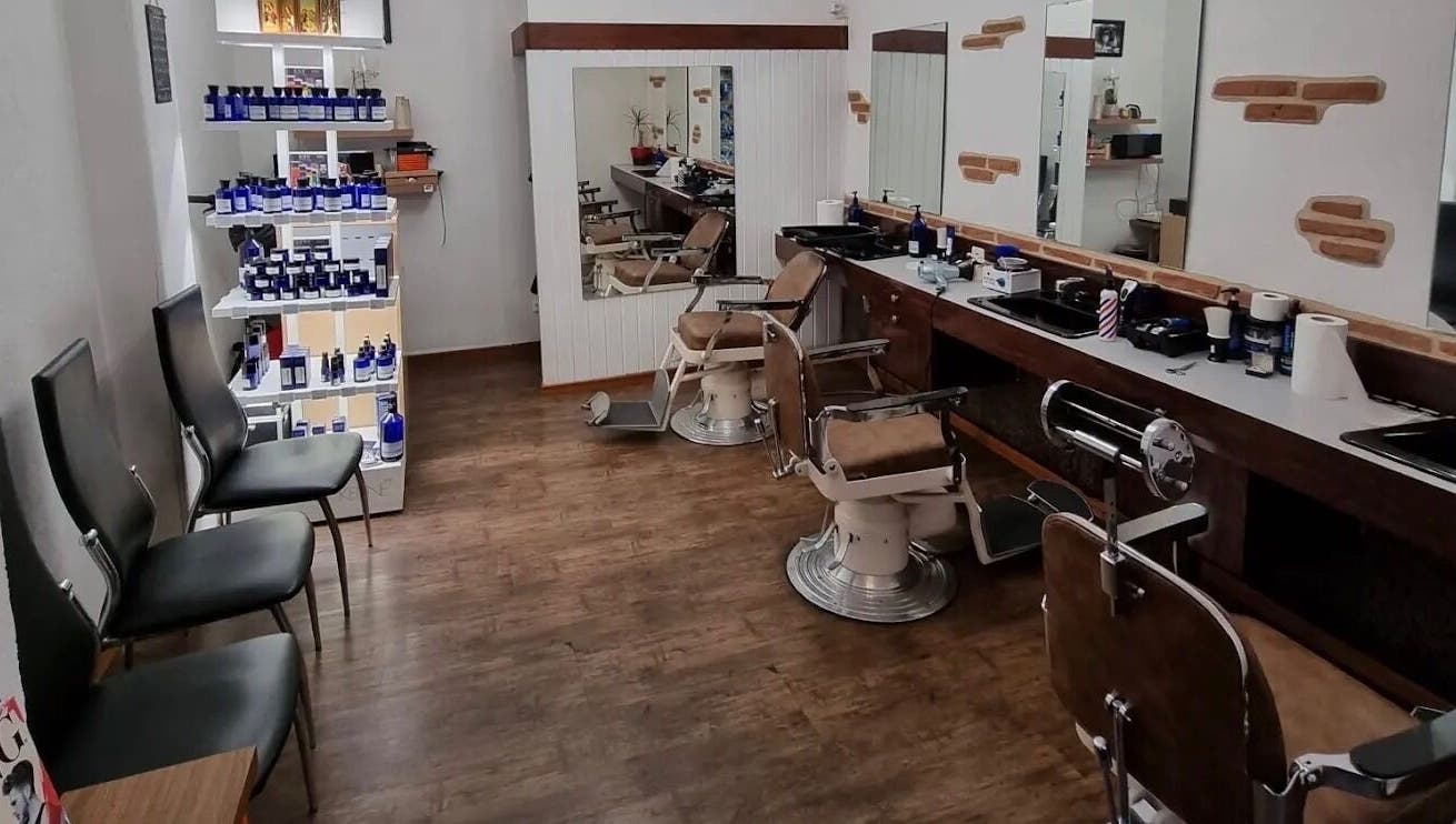 Salon de Coiffure Men's à Genève, CH, avec chaises de barbier vintage et produits de soin.