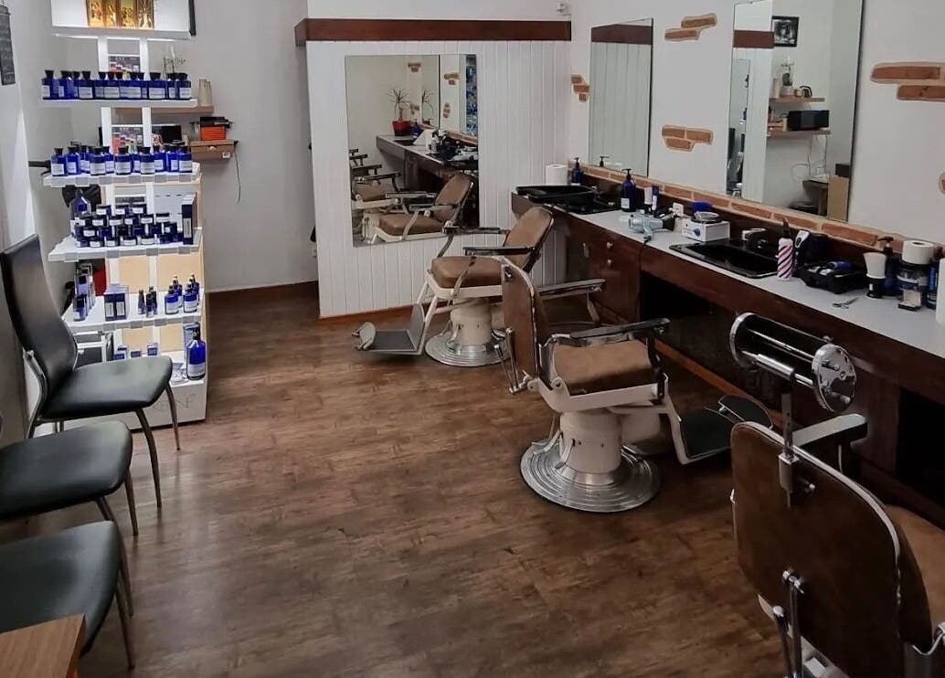 Salon de Coiffure Men's à Genève, CH, avec chaises de barbier vintage et produits de soin.