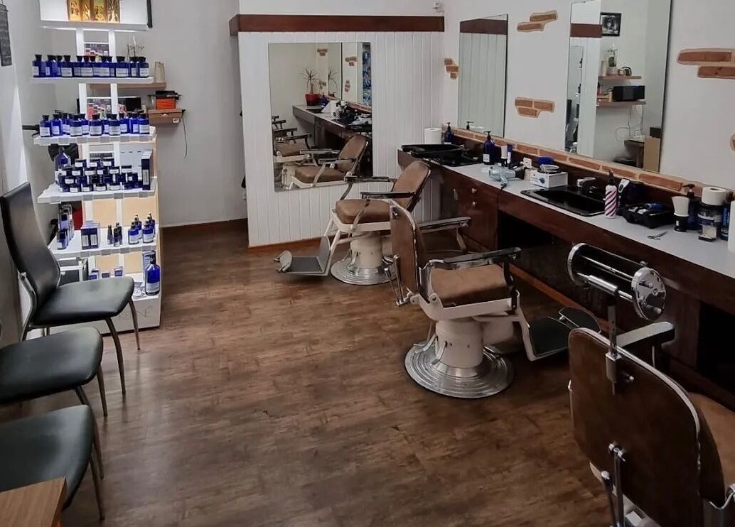 Salon de Coiffure Men's à Genève, CH, avec chaises de barbier vintage et produits de soin.