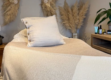 Cozy treatment room at The Wellness Pod in Woodborough, England, GB with neutral decor and wellness products.