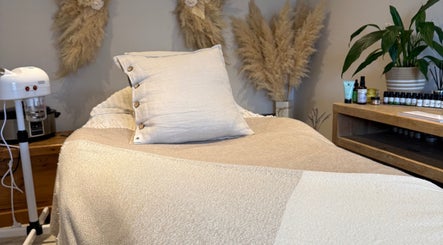 Cozy treatment room at The Wellness Pod in Woodborough, England, GB with neutral decor and wellness products.
