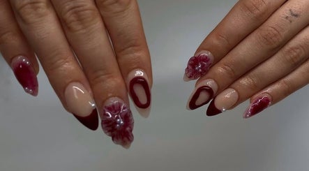 Elegant nail art at IB NAILZ, Edinburgh, Scotland, GB featuring intricate red and nude designs with floral accents.