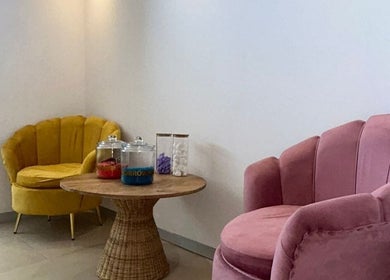 A cozy waiting area at Joocee IV Therapy, Ballito, Kwazulu-natal, ZA with stylish pink and yellow chairs.