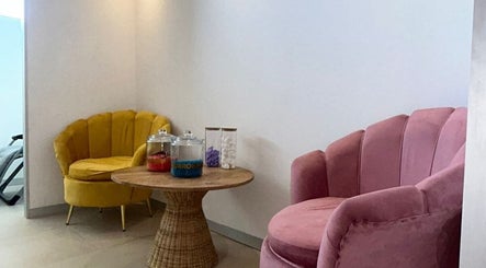 A cozy waiting area at Joocee IV Therapy, Ballito, Kwazulu-natal, ZA with stylish pink and yellow chairs.