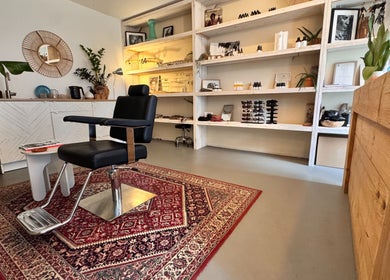 Interieur van Irie Dreads Bonaire in Kralendijk, Bonaire, BQ met een stijlvolle kappersstoel en houten inrichting.