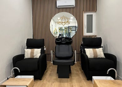 Elegante salón de Uñas, cejas & pestañas Auri en Madrid, Comunidad De Madrid, ES con cómodos sillones negros.