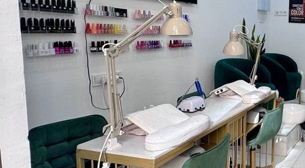 Estación de uñas en Laury Salon y Belleza, Madrid, Comunidad De Madrid, ES, con sillas verdes y lámparas.