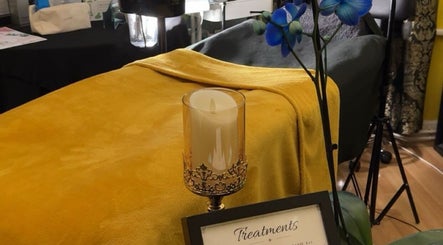 Cozy treatment room at nisas_skin, Edgware, England, GB with yellow blanket and candle.