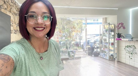 Vue de l'intérieur du salon Gisela Ferrino Coiffeuse Indépendante à Biel, Bern, CH avec une styliste souriante.