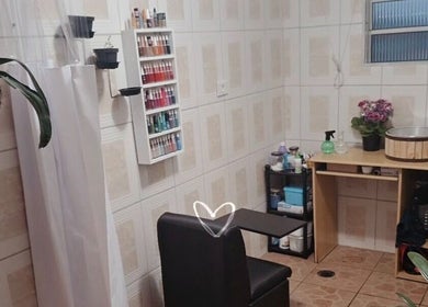 Espaço aconchegante da Tai Unhas em São Paulo, São Paulo, BR, com cadeira e prateleira de esmaltes.
