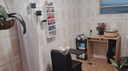 Espaço aconchegante da Tai Unhas em São Paulo, São Paulo, BR, com cadeira e prateleira de esmaltes.
