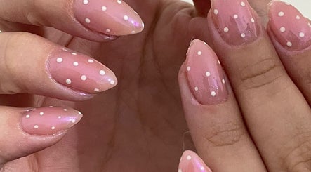 Uñas decoradas con esmalte rosa y puntos blancos en Afrodita Estética, Rosario, Santa Fe, AR.