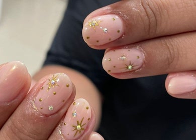 Uñas decoradas con estrellas doradas en Afrodita Estética, Rosario, Santa Fe, AR.
