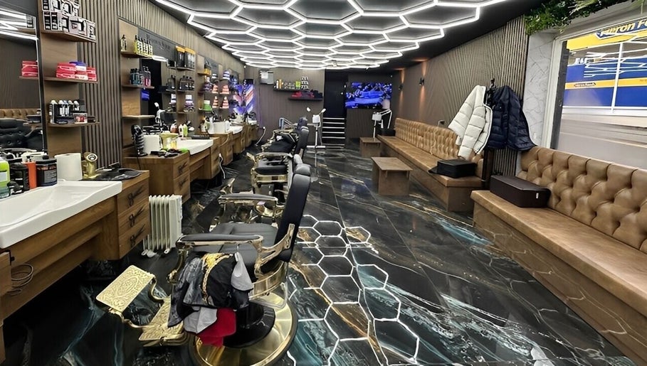 Modern barbershop interior at Style Cutz, Ilkeston, England, GB, featuring hexagonal lighting and sleek furnishings.