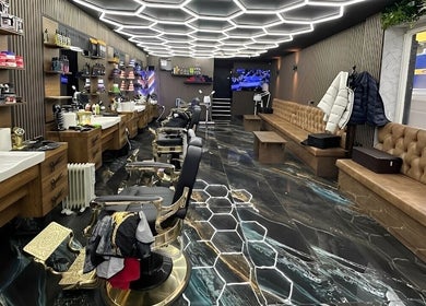 Modern barbershop interior at Style Cutz, Ilkeston, England, GB, featuring hexagonal lighting and sleek furnishings.
