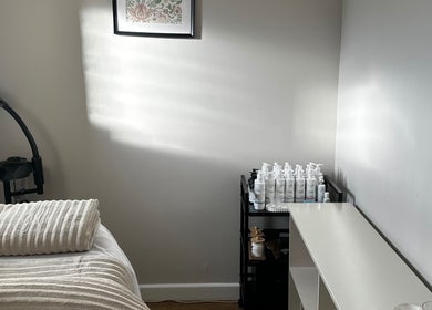 Calming treatment room at Beauty by Claudie with cozy bed, products, and decor in Gamlingay, England, GB.