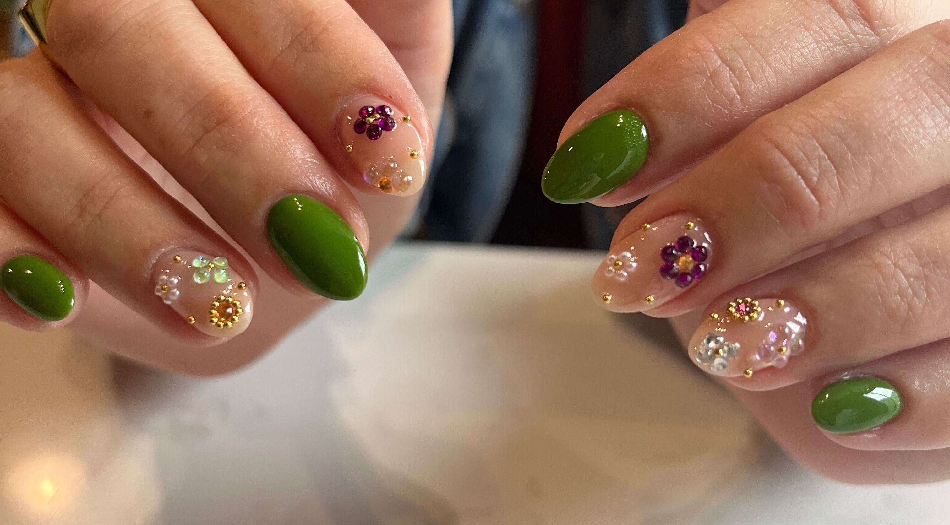 Colorful floral nail art with green accents at Speakeasy Nail Studio, Lynnwood, Washington, US.