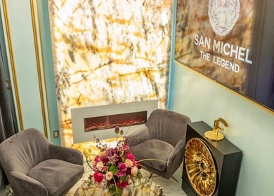 Cozy lounge area at San Michel The Legend Barbershop in Glendale, California, US with plush chairs and floral decor.