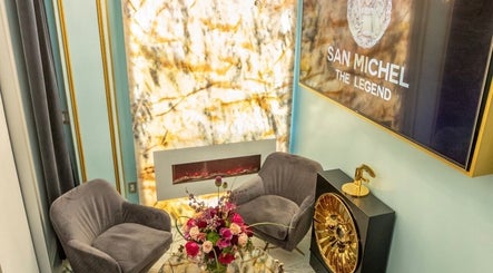 Cozy lounge area at San Michel The Legend Barbershop in Glendale, California, US with plush chairs and floral decor.