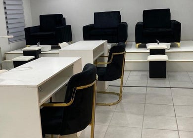 Pedicure and manicure stations at The Chosen Beauty Spa in Sandton, Gauteng, ZA, showcasing sleek black chairs.