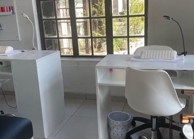 Bright nail station at The Chosen Beauty Spa, Sandton, Gauteng, ZA, with chairs and polish display.