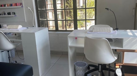 Bright nail station at The Chosen Beauty Spa, Sandton, Gauteng, ZA, with chairs and polish display.