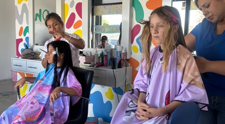 Niñas divirtiéndose en Kids & Cuts Fun Studio en Mexicali, Baja California, MX durante un corte de cabello.