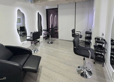 Interior moderno de Euphoria Estudio en Santiago, Región Metropolitana, CL, con sillas y espejos iluminados.