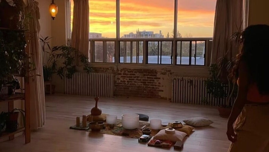 Warm sunrise in Pilatique studio, Montréal, Québec, CA, with meditation setup and serene ambiance.