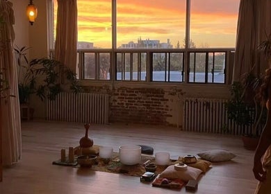 Warm sunrise in Pilatique studio, Montréal, Québec, CA, with meditation setup and serene ambiance.