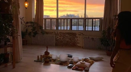 Warm sunrise in Pilatique studio, Montréal, Québec, CA, with meditation setup and serene ambiance.