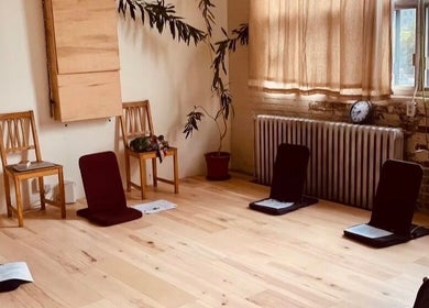 Warm, inviting room at Pilatique, Montréal, Québec, CA with chairs and cushions for meditation.