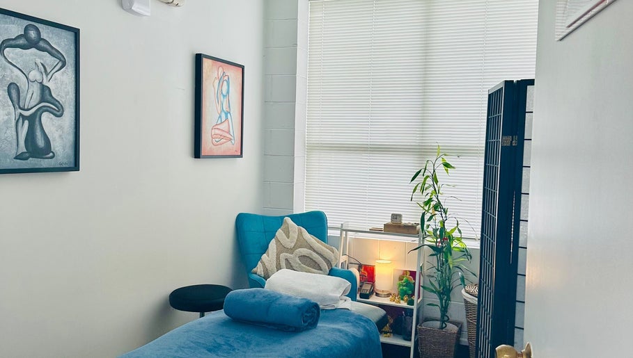 Relaxing therapy room at Therapeia Limited in Auckland, Auckland, NZ, featuring art, plants, and cozy seating.