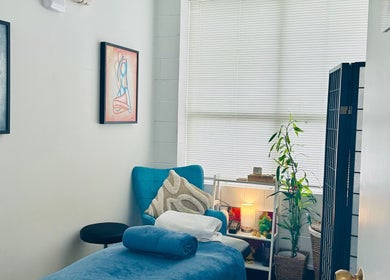 Relaxing therapy room at Therapeia Limited in Auckland, Auckland, NZ, featuring art, plants, and cozy seating.