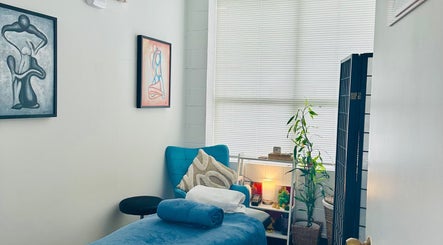 Relaxing therapy room at Therapeia Limited in Auckland, Auckland, NZ, featuring art, plants, and cozy seating.