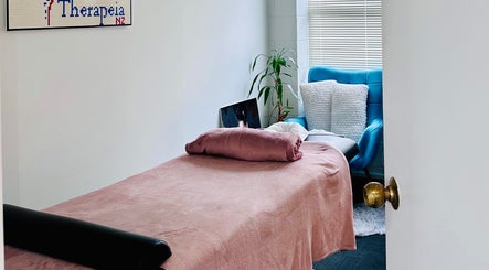 Cozy massage room at Therapeia Limited, Auckland, Auckland, NZ, featuring a plush bed and calming decor.
