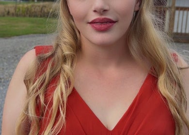 Woman in red dress at Glam’d Luxxe, Hubbard, Ohio, US, radiates elegance and style.