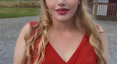 Woman in red dress at Glam’d Luxxe, Hubbard, Ohio, US, radiates elegance and style.