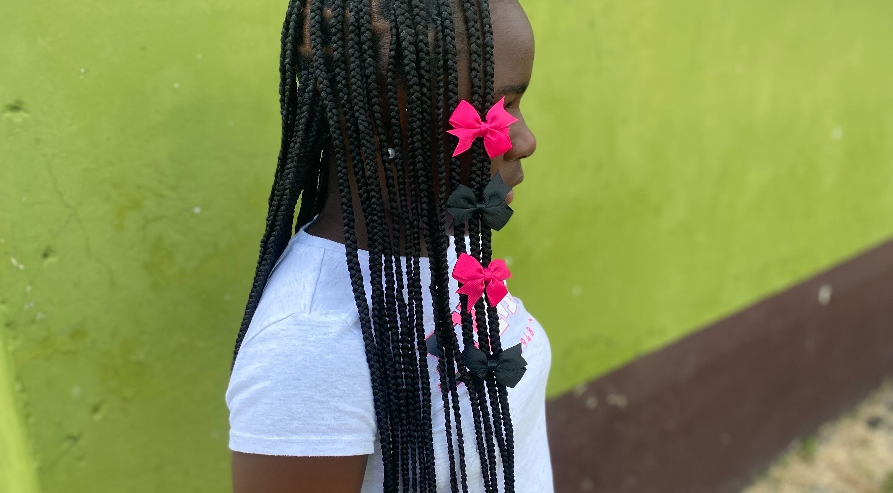 Braided hairstyle with pink bows at Beautyparlourbds, Bridgetown, Saint Michael, BB.