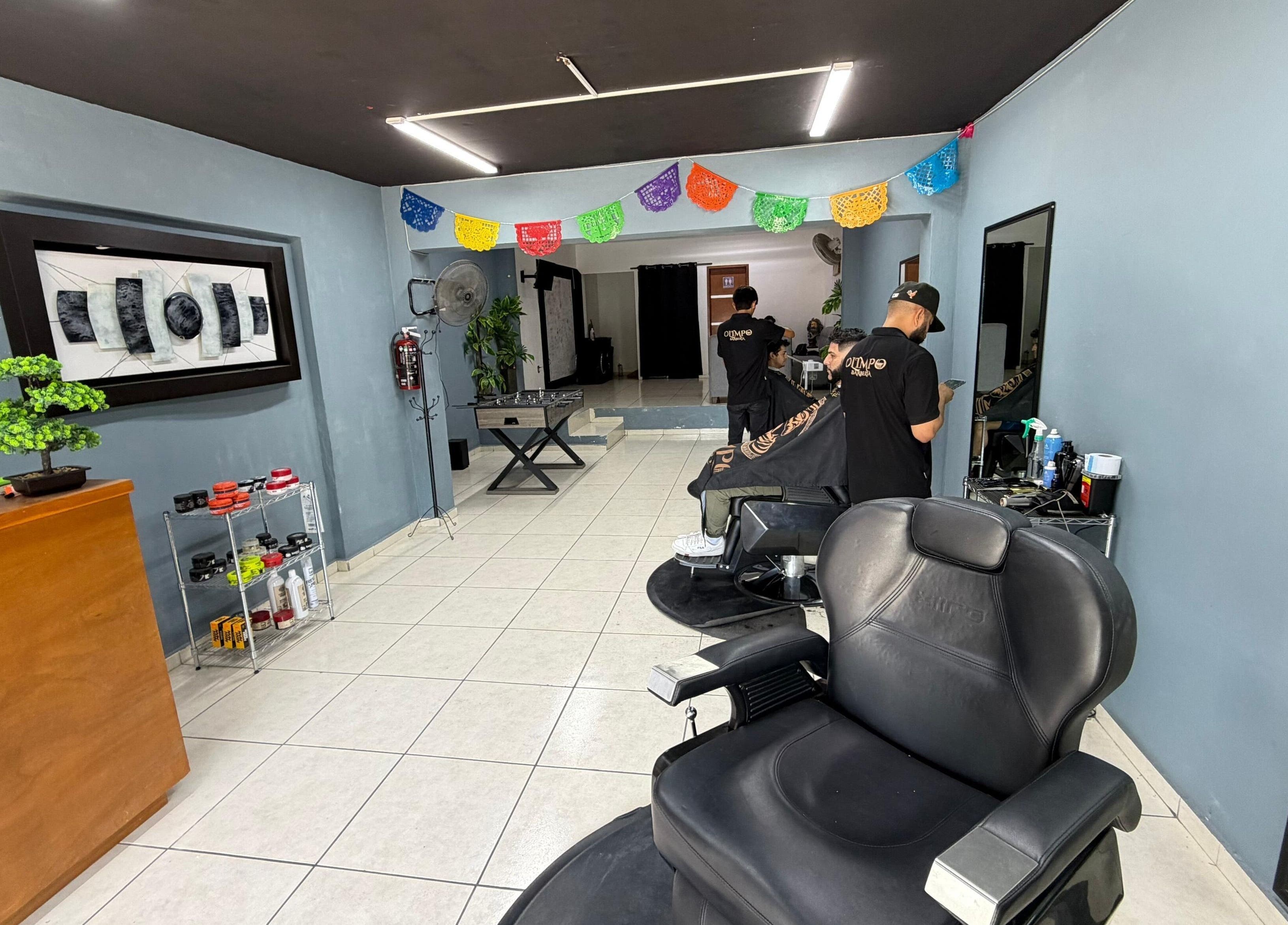 Interior acogedor de Barbería Olimpo en Tepic, Nayarit, MX, con modernas estaciones de corte.