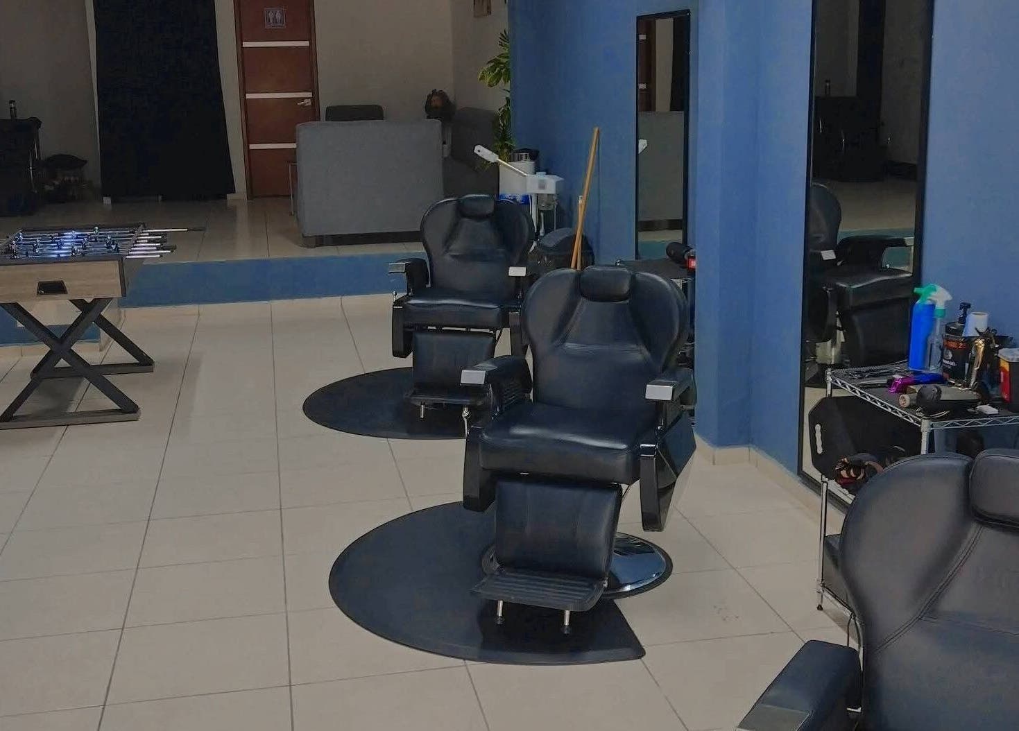 Interior moderno de Barberia Olimpo en Tepic, Nayarit, MX con sillas de peluquería y mesa de futbolito.
