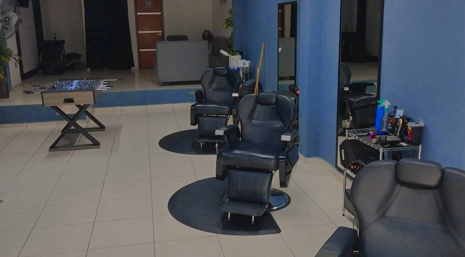 Interior moderno de Barberia Olimpo en Tepic, Nayarit, MX con sillas de peluquería y mesa de futbolito.