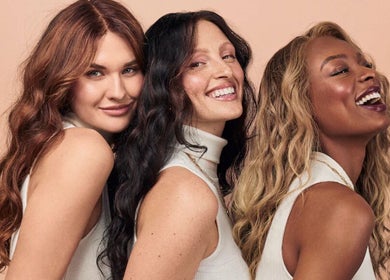 Three women smiling, showcasing diverse beauty at Amber Jean, London, England, GB.