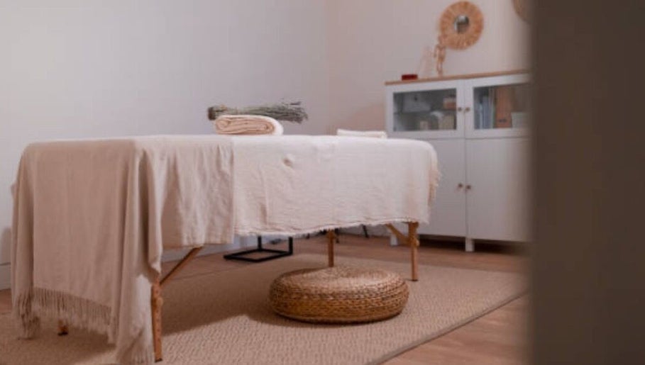 Massage room at Nicolai Holistic, London, England, GB with a cozy table and natural decor.