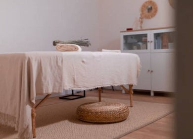 Massage room at Nicolai Holistic, London, England, GB with a cozy table and natural decor.