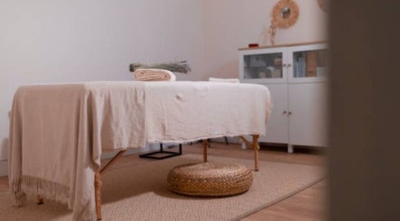 Massage room at Nicolai Holistic, London, England, GB with a cozy table and natural decor.
