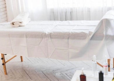 Massage table at Nicolai Holistic, London, England, GB, set for relaxation and wellness treatments.