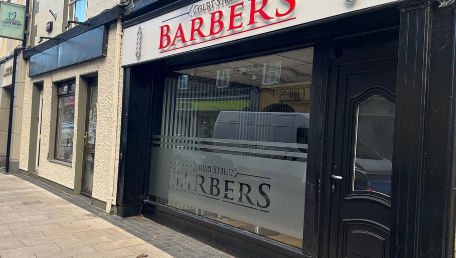 Court Street Barbers facade in Enniscorthy, County Wexford, IE featuring a stylish black doorway.