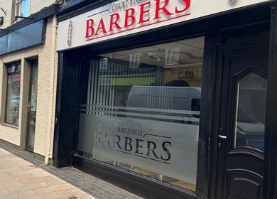 Court Street Barbers facade in Enniscorthy, County Wexford, IE featuring a stylish black doorway.